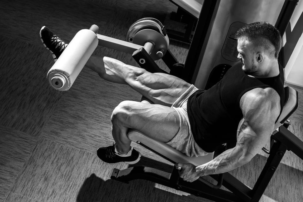 gym. man doing leg workout. black and white